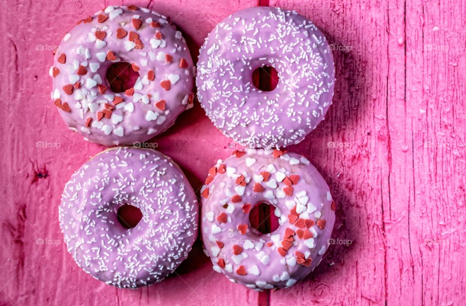 Colourful donuts on pink table