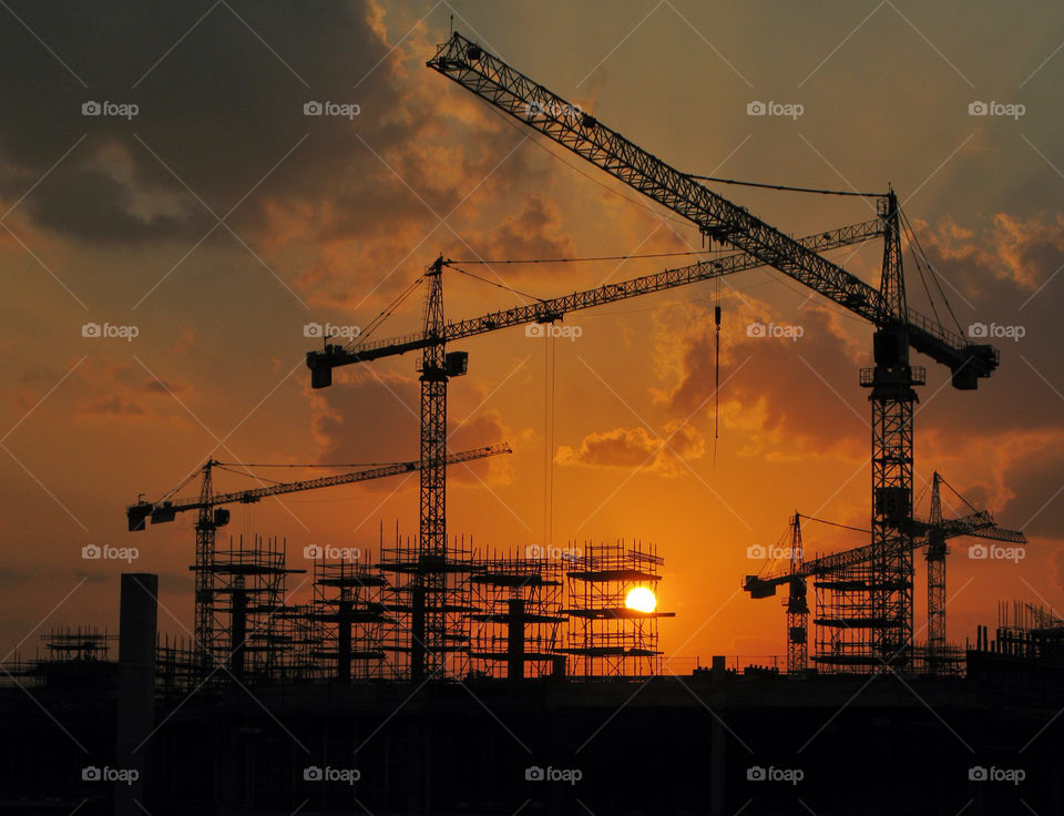 Silhouette crane at construction Site during sunset