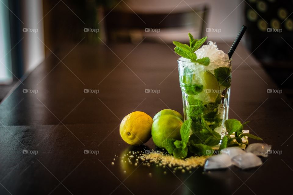 Caipirinha cocktail decorated with sugar and lemons on wooden table