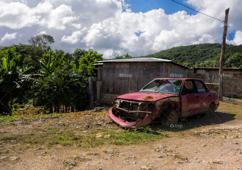 Broken and rusty car left abandoned in lush environment in the outskirts of Boston Bay in Portland parish, Jamaica on 30 December 2013.