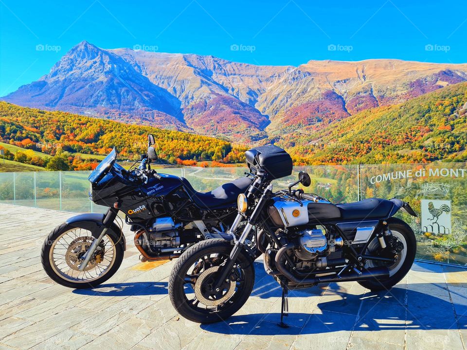 departing motorbikes surrounded by a mountain landscape