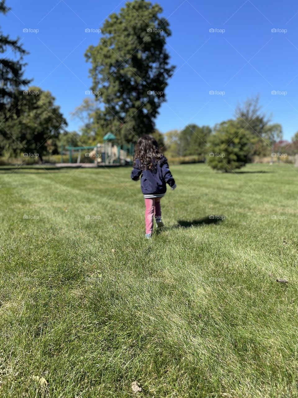 Child running in the park, toddler runs towards playground, out in the open, enjoying the outdoors, fall time in the Midwest, enjoying the playground in October