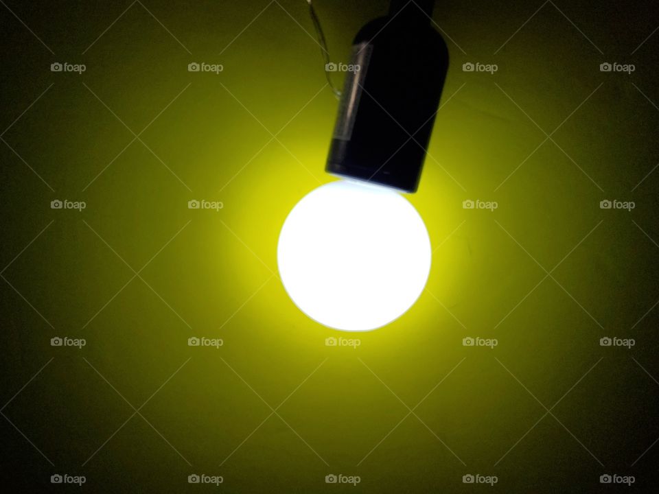 Artificial light:  Bright light bulb in front of a yellow background