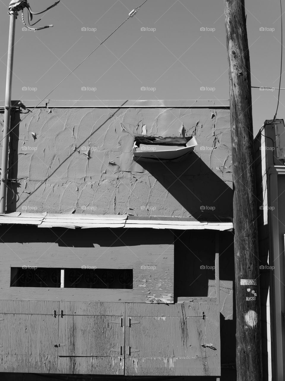 The side of an old concrete building in a city with windows on a sunny summer day. 