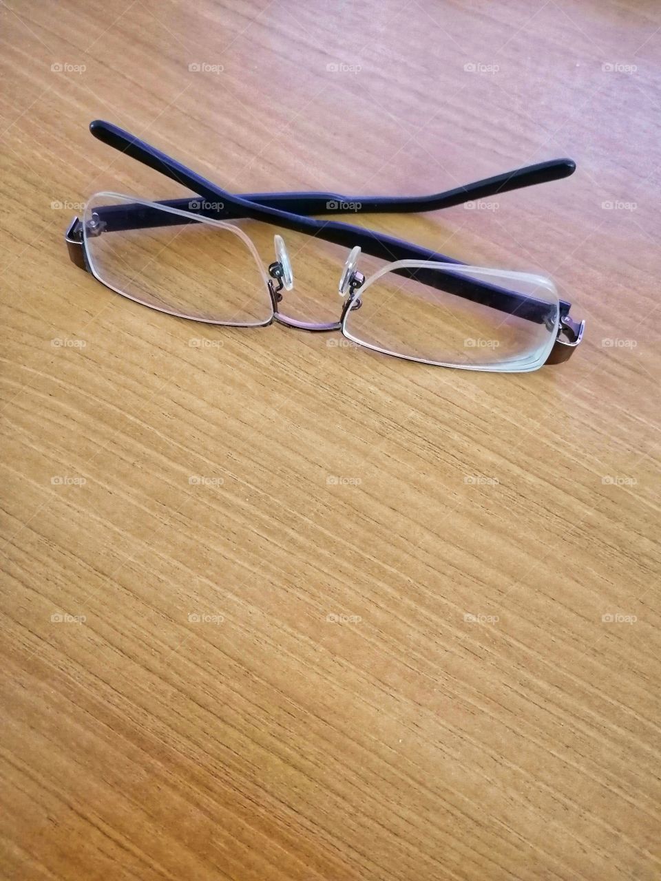Short-sighted glasses on brown wood floors