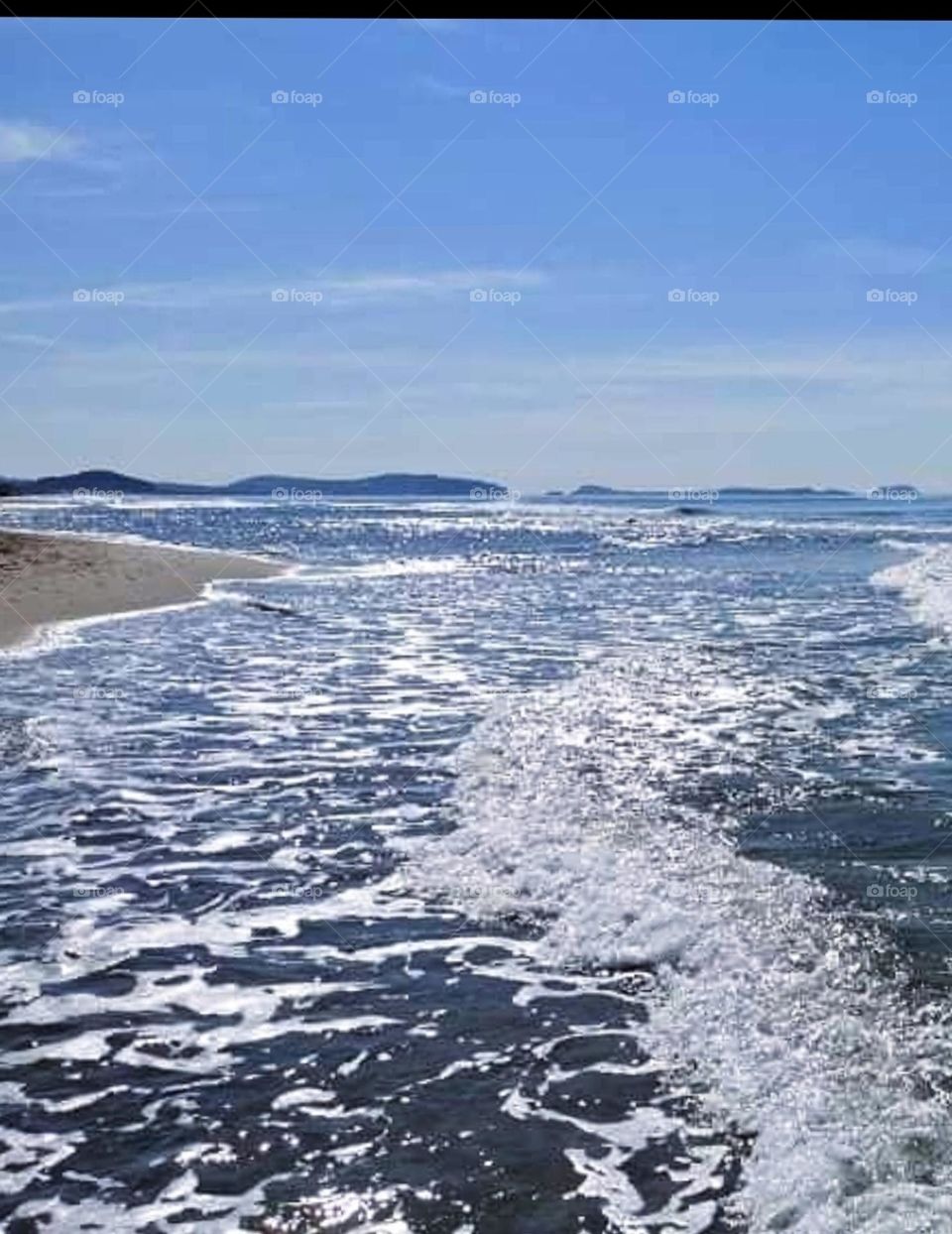 Clear blue sea with small waves in contrast to the blue sky