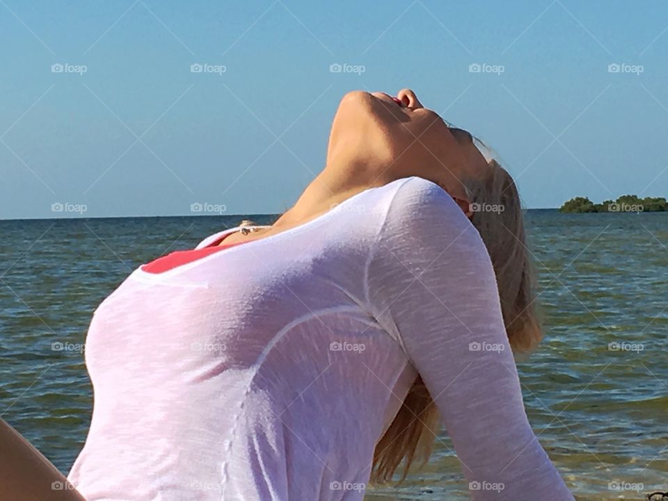 Elegant woman bending backwards at sea