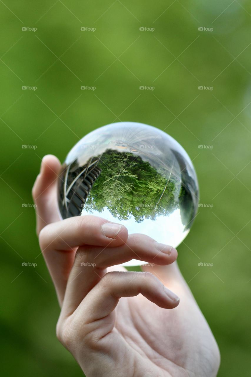Glass ball in nature held by hand 