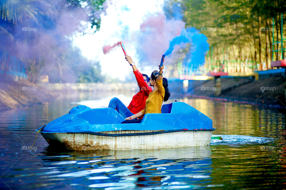 Couple sitting in boat with smoke bomb