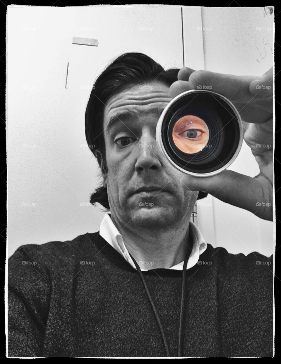 Looking through a cannon lens in black & white with a colored eye