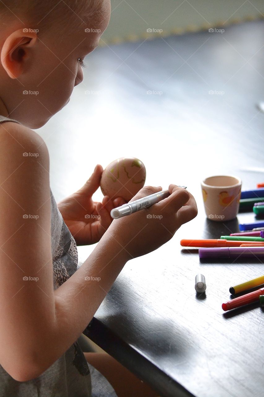 Boy painting easter egg