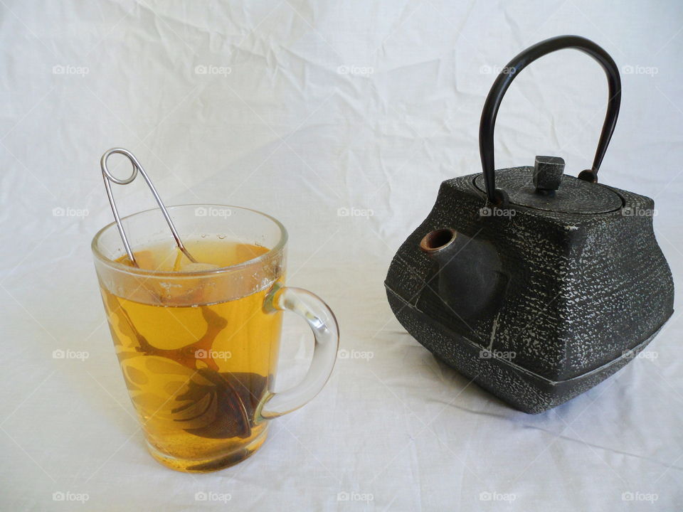 tea pot and a cup of green tea on a white background