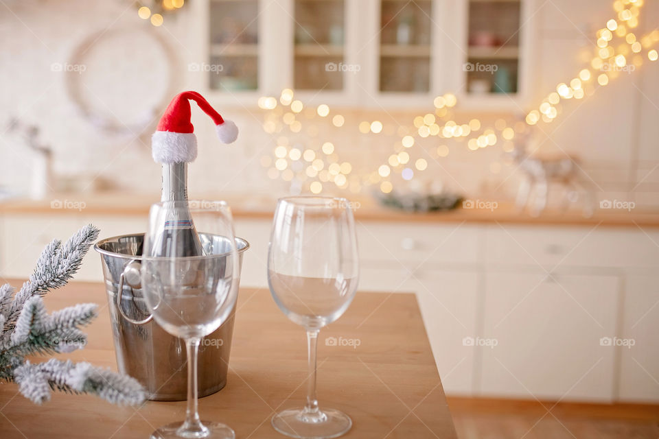 Festive winter cozy kitchen interior with garlands, decorations and gifts.  Christmas dinner at the decorated table.