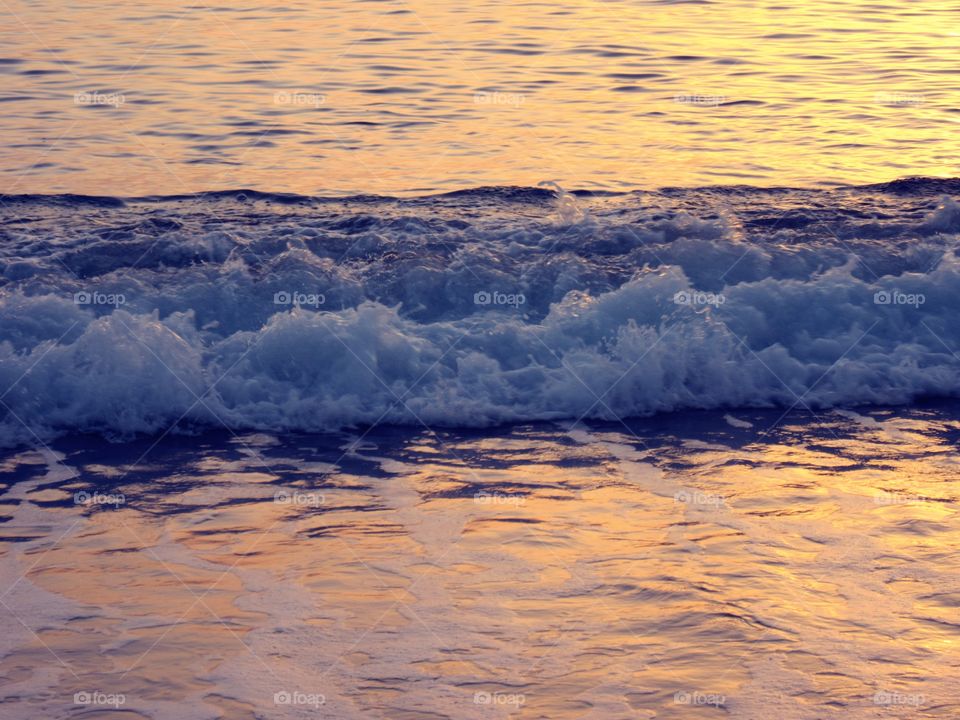 Waves of the sea at sunset ( Praia - Italy ).
