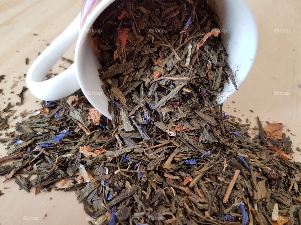 Herb tea spilling from cup