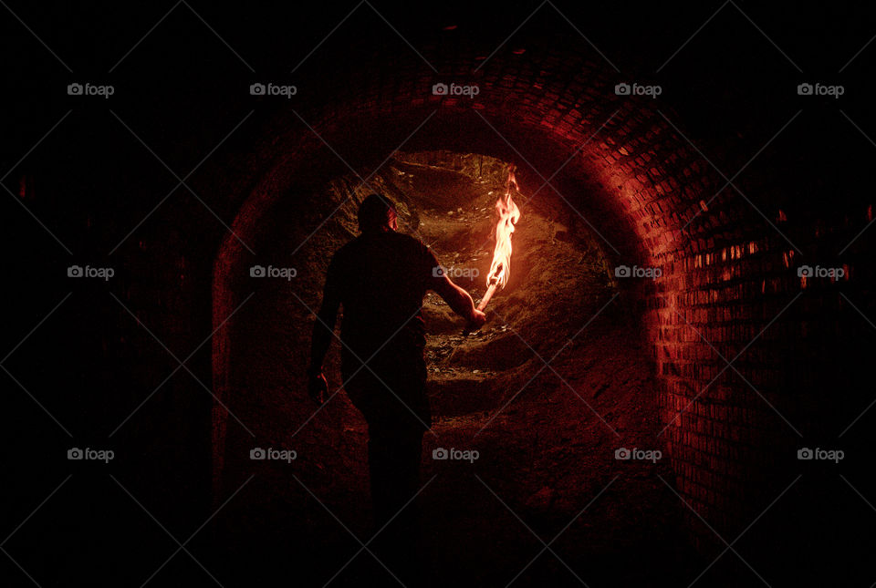 Man with ancient torch in the underground.