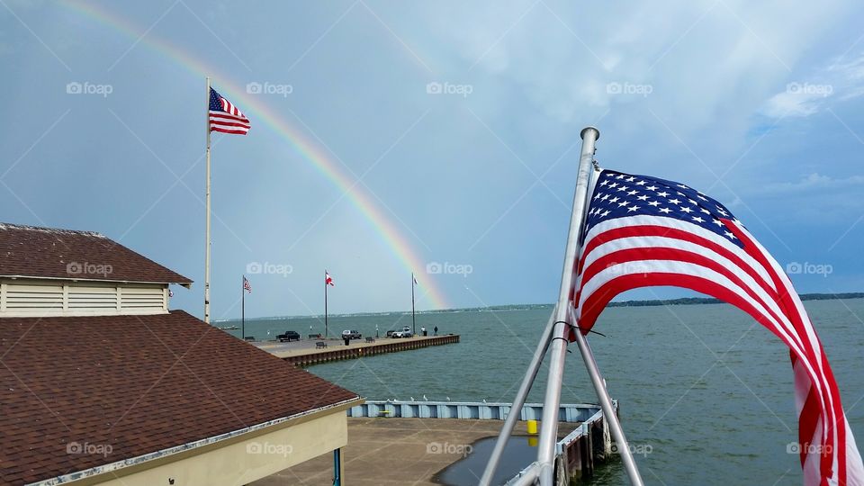 American flags and rainbow over the lake