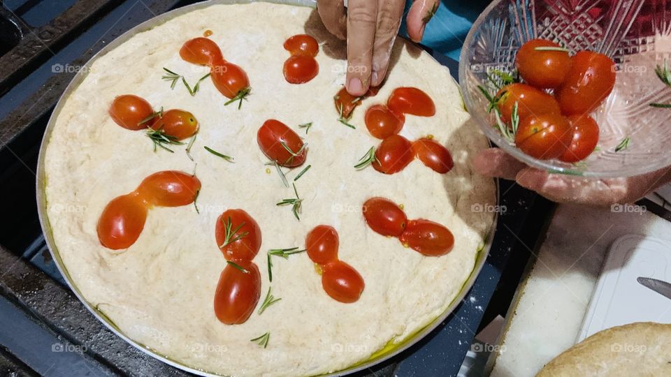 Making pizza with cherries tomatoes 
