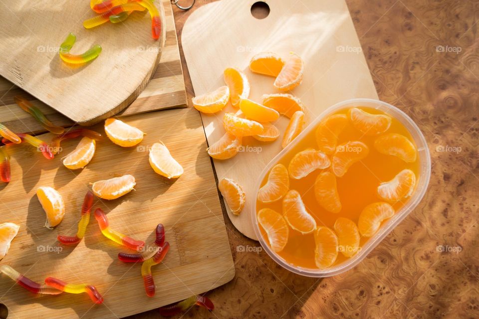 Delicious orange jelly with tangerine slices in a container and jelly worms.
