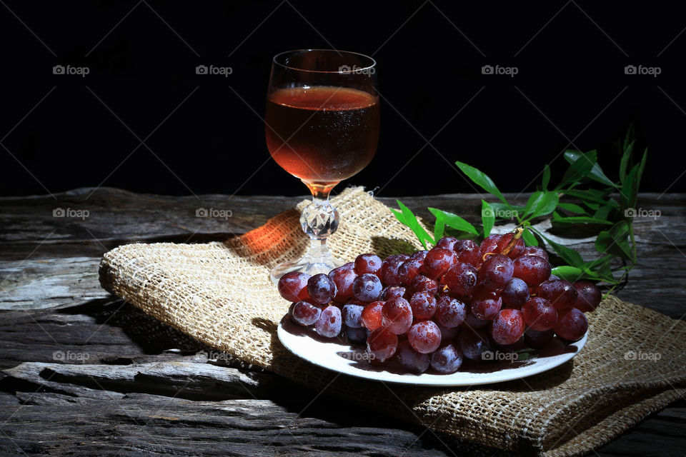 Red grapes and wine grapes on wooden board background.