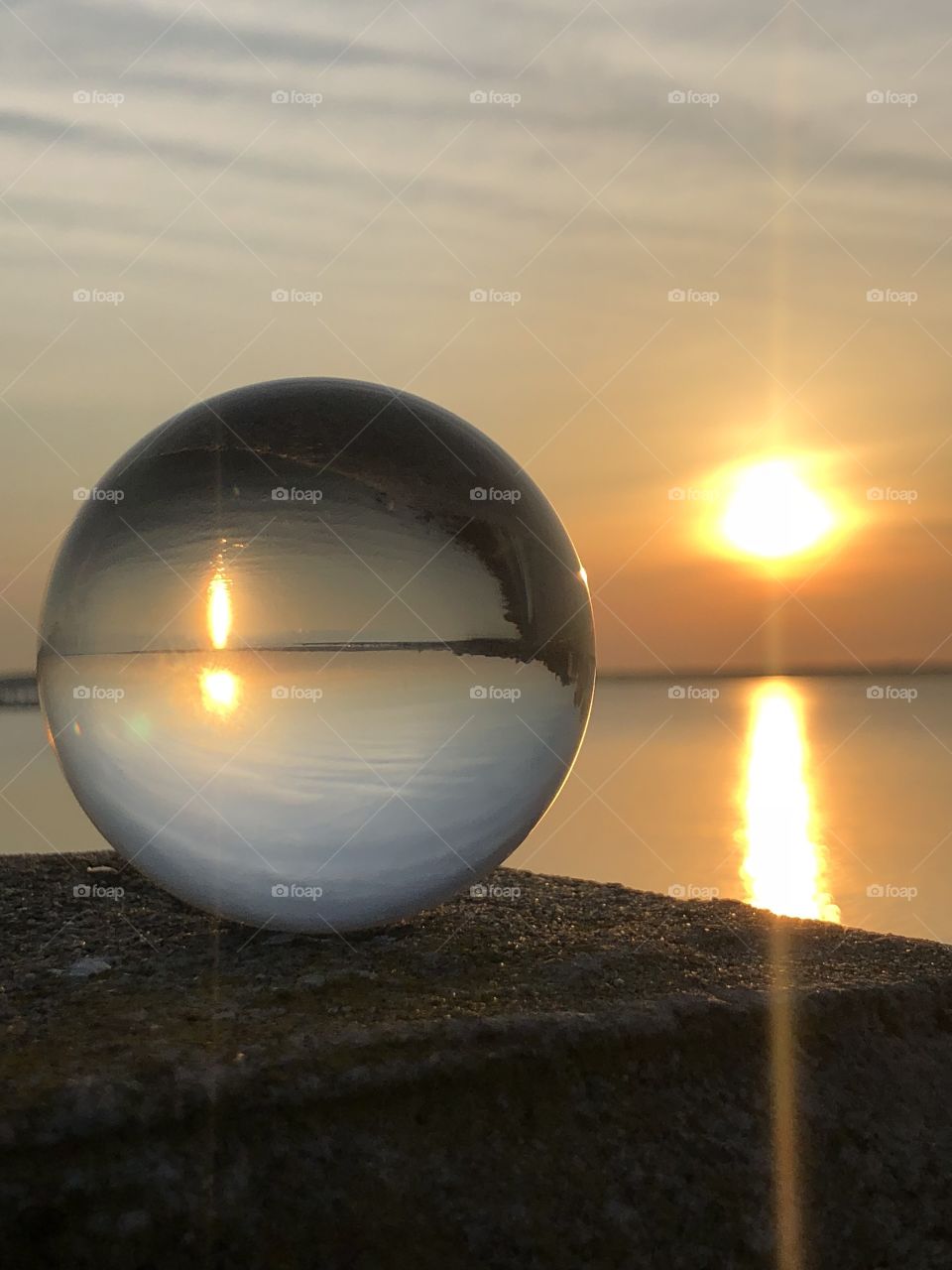 Glass ball showing refracted image of sunrise over the battery in downtown Charleston, South Carolina 