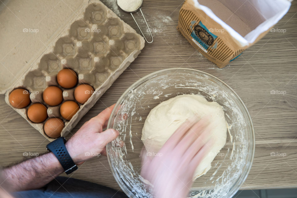 Things we love - baking and making bread. Image of man kneading dough with eggs and flour.