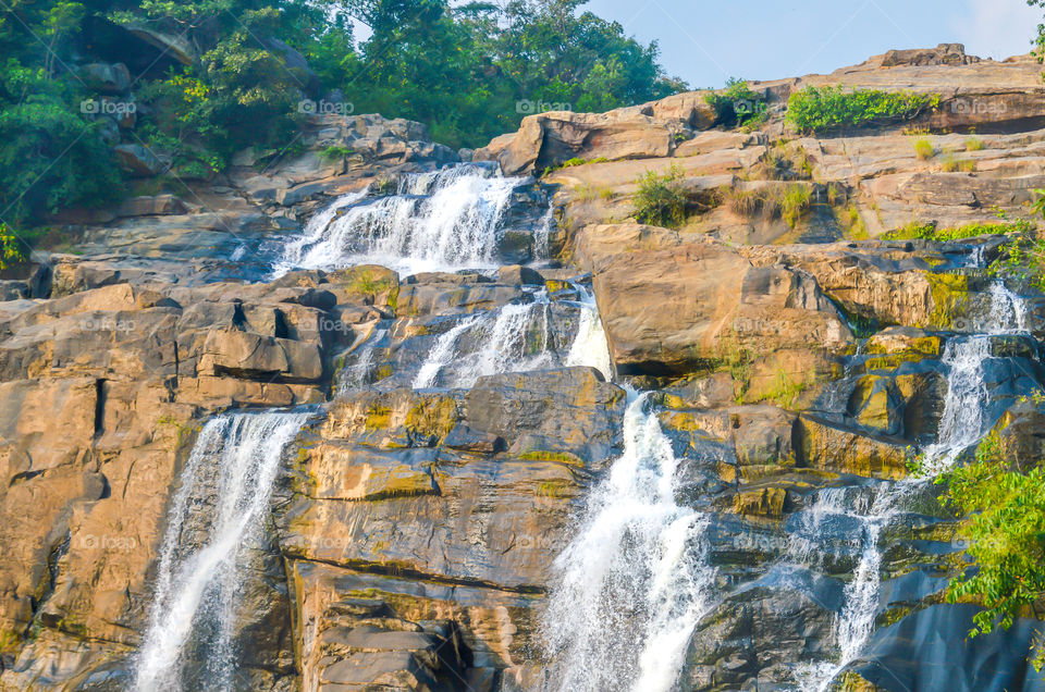 Breathtaking waterfalls panorama in Corbett National park, India. Lakes National Park. Majestic view of turquoise water and sunny beams. Small wonderful refreshing waterfalls and the rocks.