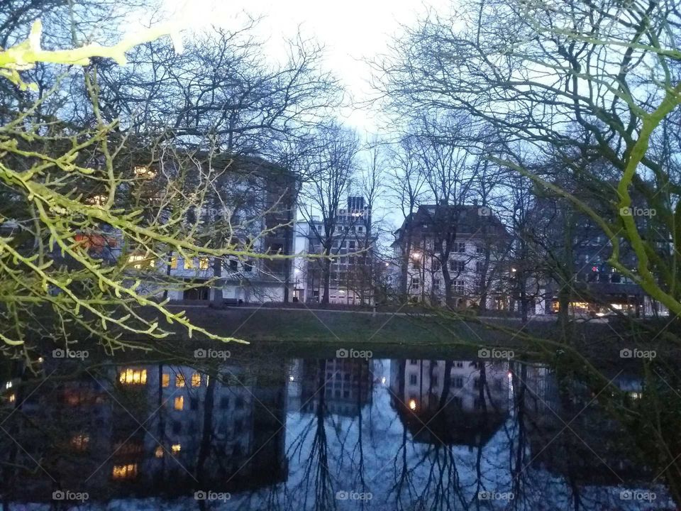 Reflections of a house in water at dusk in Bremen Germany