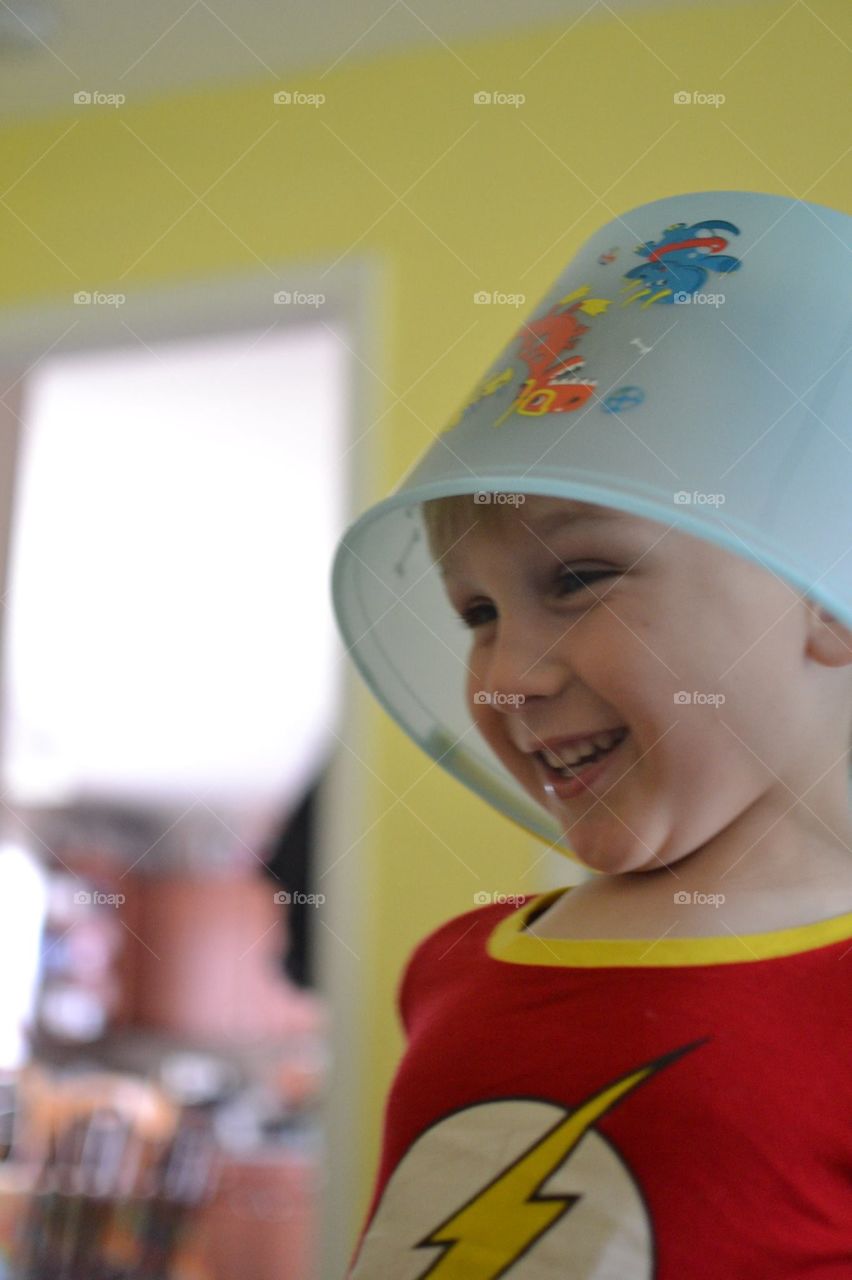 Smiling boy with bucket in his head