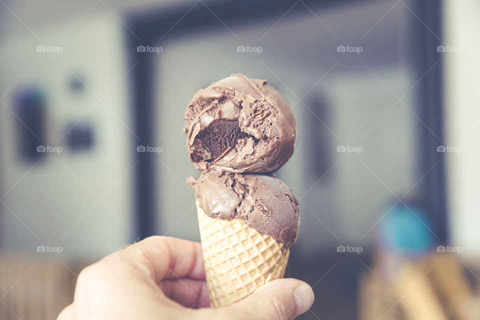 Person holding chocolate ice cream cone
