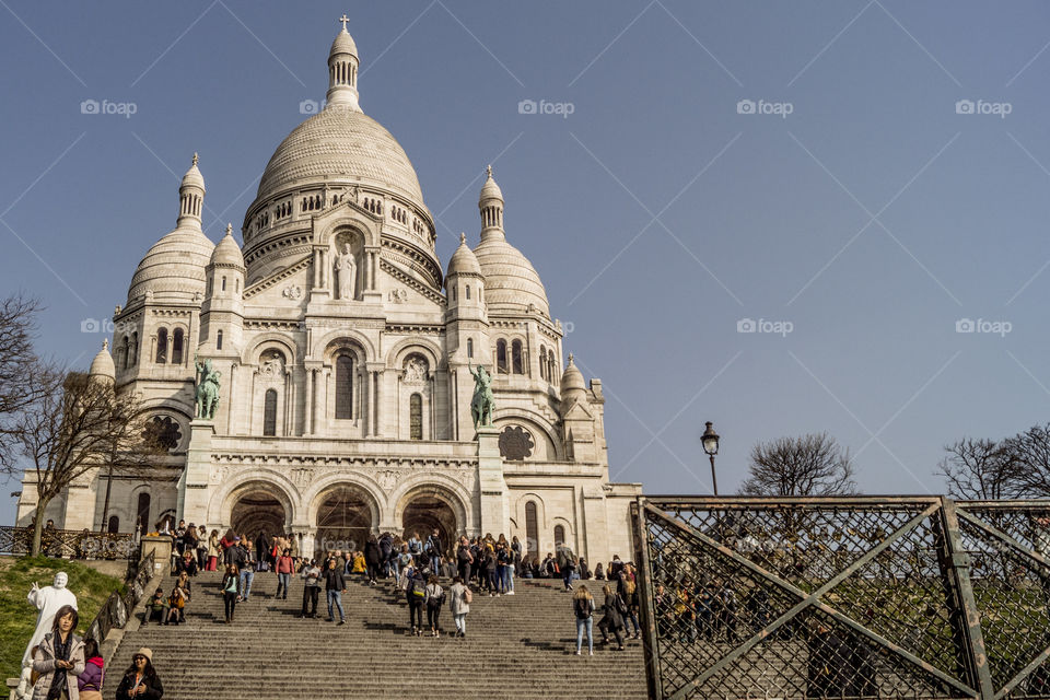 The sacré cœur of Paris, It's a famous temple in the world with withe walls and a dome, it' s crowded of people.