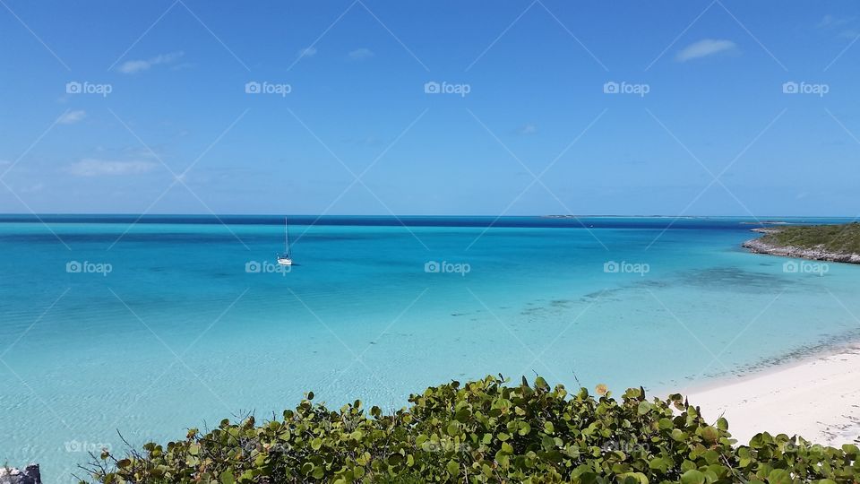 breathtaking blue waters with sailboat in Bahamas