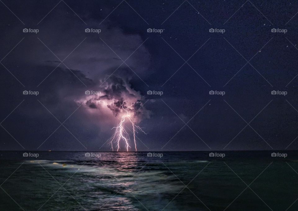 Thunderstorm and lightning over the sea at night 
