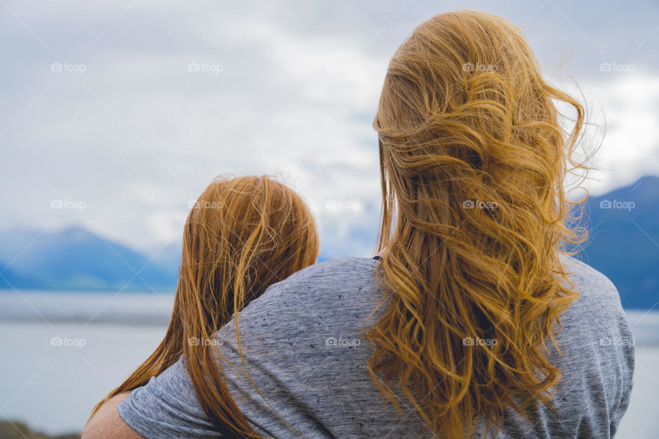 Mother & daughter enjoy the mountain lake. 