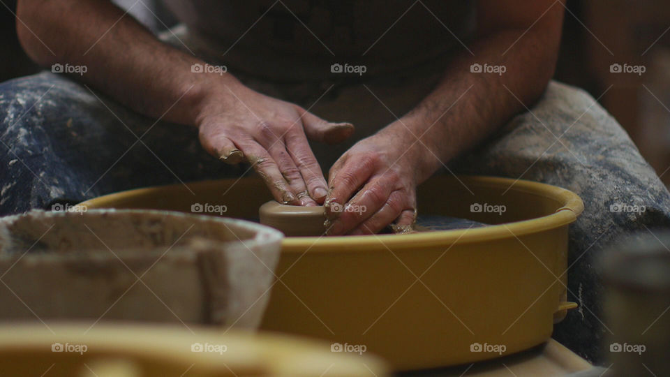 Potter's hands making clay pot