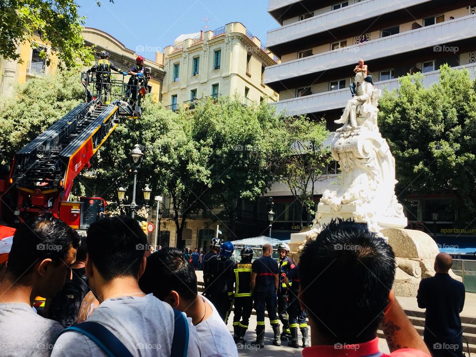 a man try to jump from statue in Rambla street Barcelona 