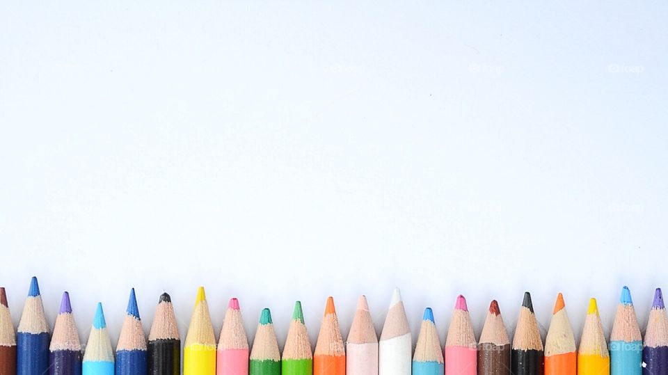 Multi colored pencils againts white background