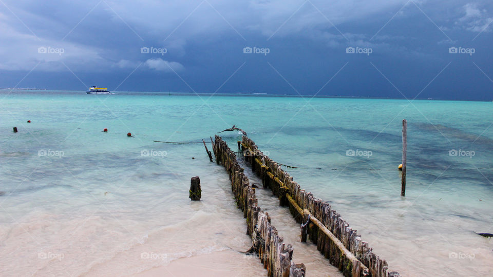 Beach in Isla Mujeres, Mexico with Cancun in the distance, sunny and an impending storm