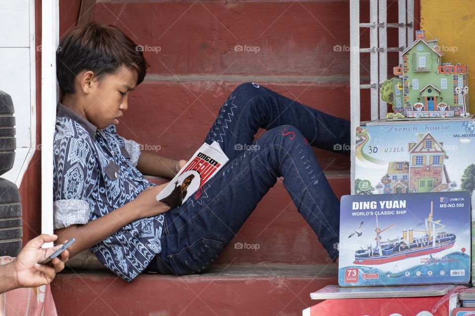 Myanmar boy read a book at street road
