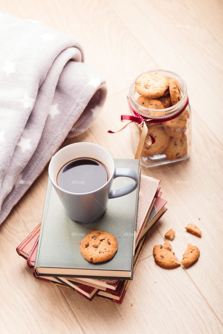 A few books with cup of coffee and cookies on wooden floor. Time for relax. Spending leisure time on reading. Cozy and comfortable. Relaxing 😌