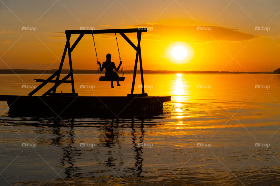 Warm summer evening. When is warm enough to watch the sunset on the lake.