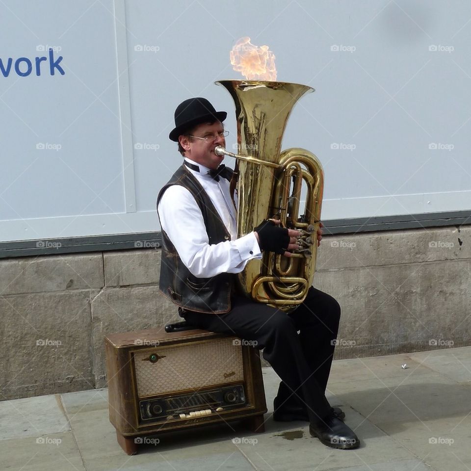 Tuba player lighting a flame, London England 