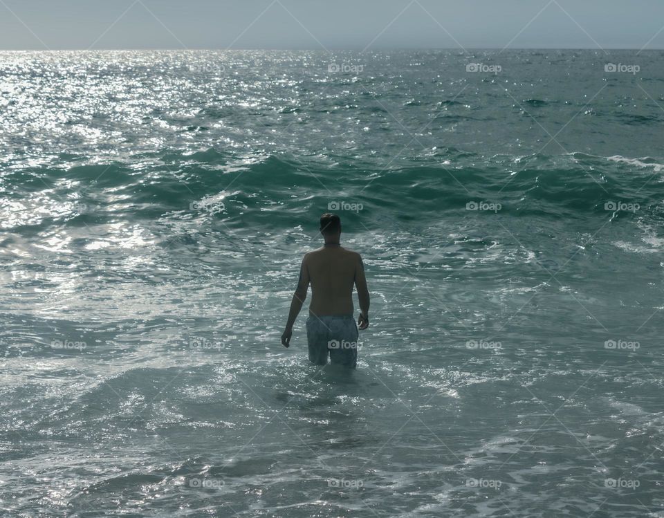 A man strides out for a swim into the Atlantic Ocean 