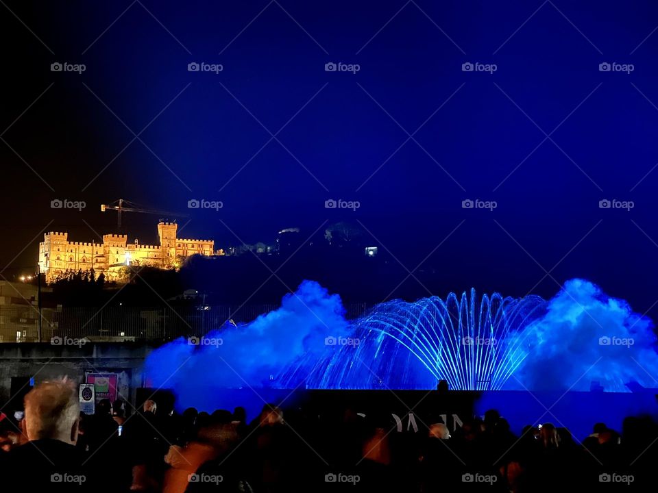 People watching at blue fountain in the night