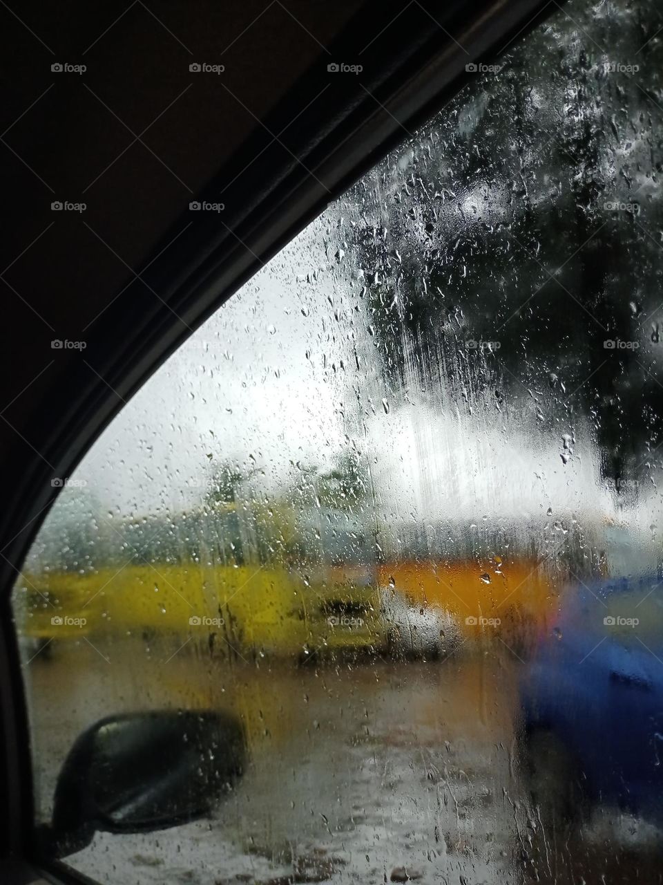 Beautiful view of the bus under the car window in rainy season yellow orange colour