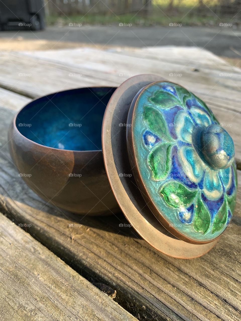 A handmade hammered copper bowl with a beautiful blue and green lid, for storage. 