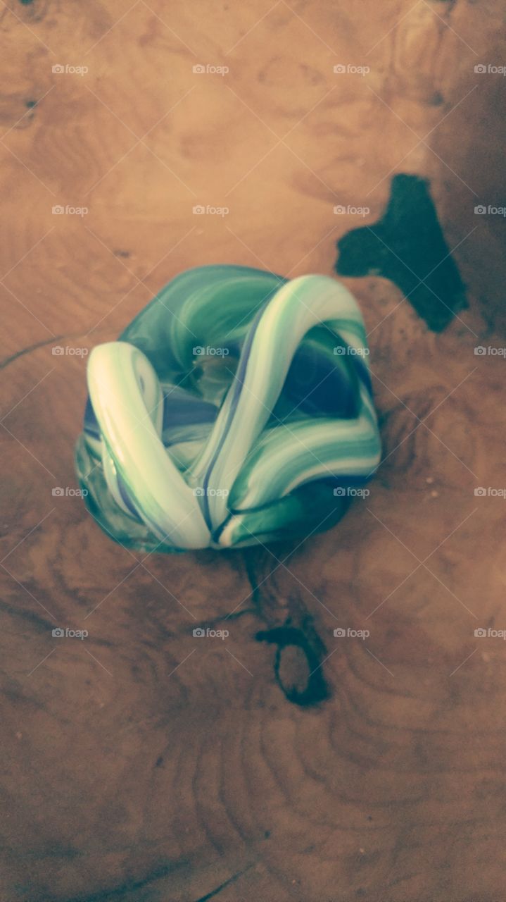 Green Glass Paperweight. Sensual shape against wood