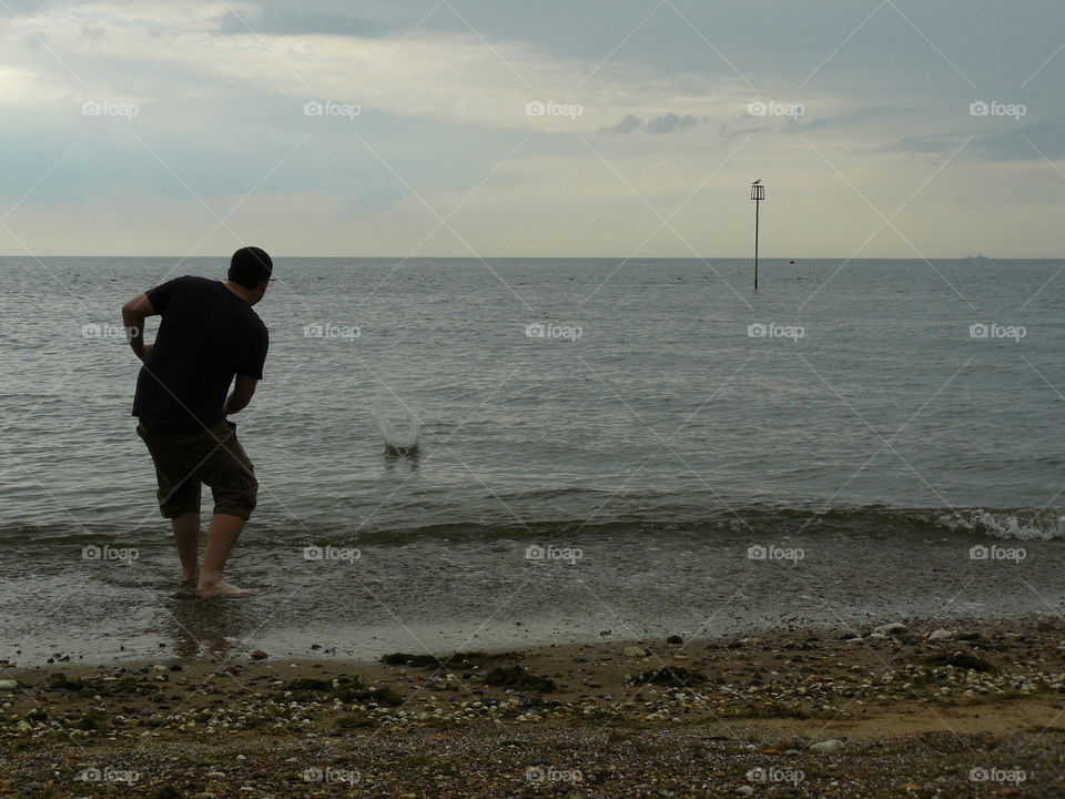 Man / boy Skimming Rocks At The beach - Seaside Holiday - Waves and Sea - Blue Sky