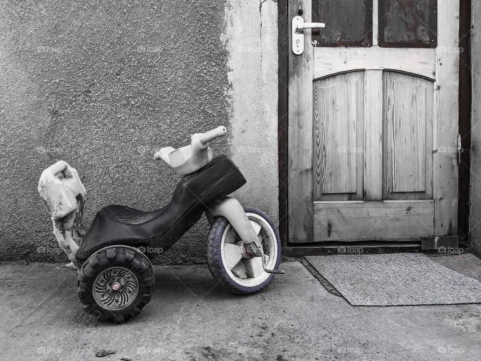 Old child bicycle near wooden door