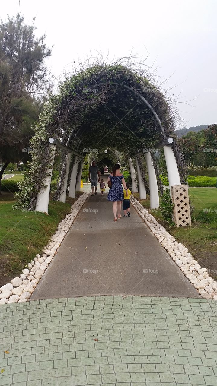People walking through a flower covered arch in Turkey